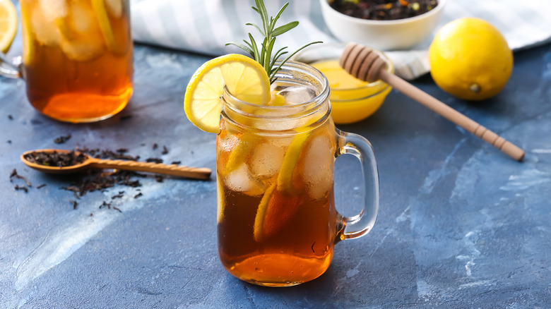 Mason jar of sweet tea with loose tea, honey, and lemon