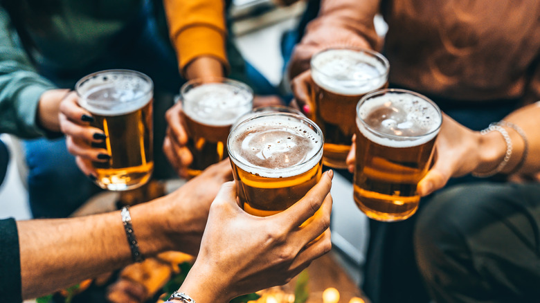 hands holding full glasses of beer