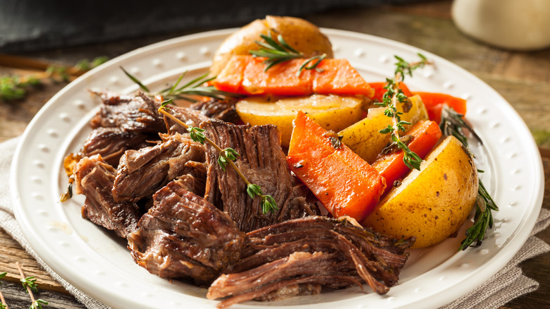 pot roast prepared in slow cooker with potatoes and carrots