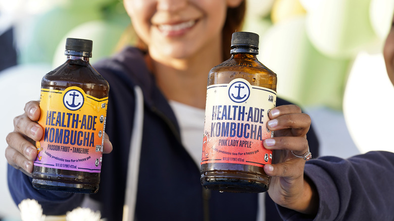 woman holding health ade kombucha