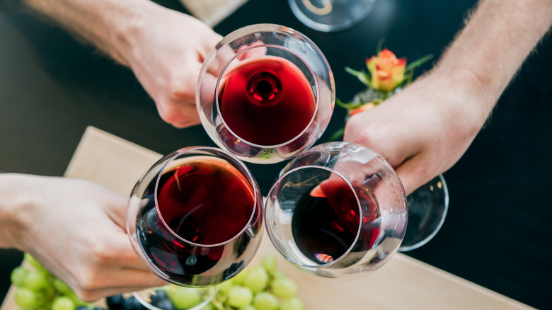 Friends toasting with three glasses of red wine