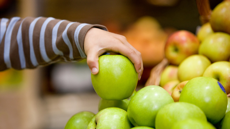 Child picking apple from display