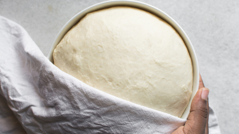 Challah dough is proofing in a bowl.