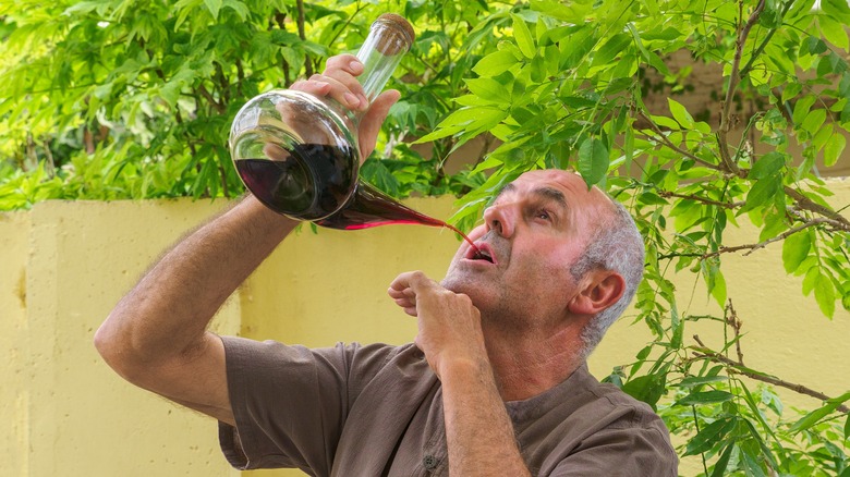 Man drinking wine from a porron