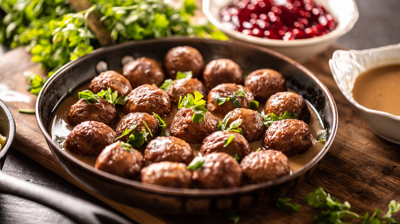 Swedish meatballs served in a skillet topped with fresh herbs