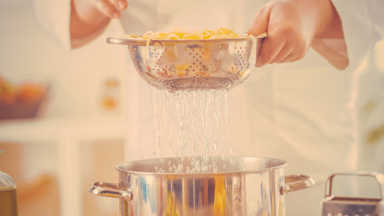 Straining pasta into a pot