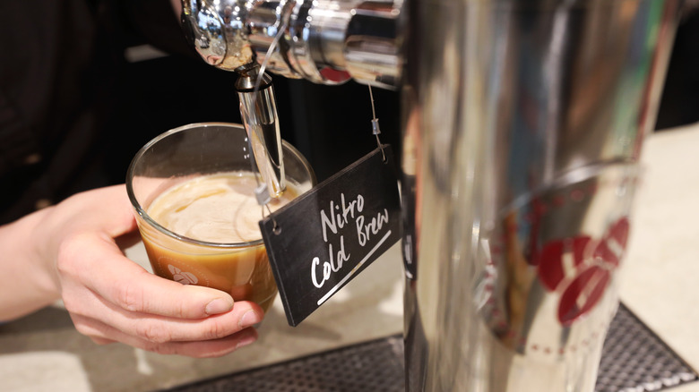 pouring nitro cold brew coffee with sign