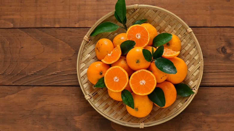 Basket of whole and halved mandarin oranges