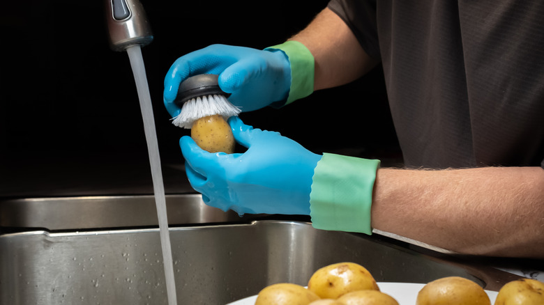 Man scrubbing and washing potato