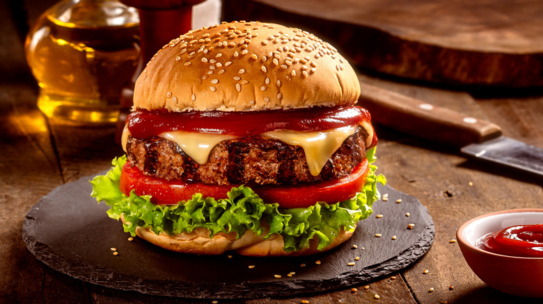 Cheeseburger with fixings on a charcoal plate