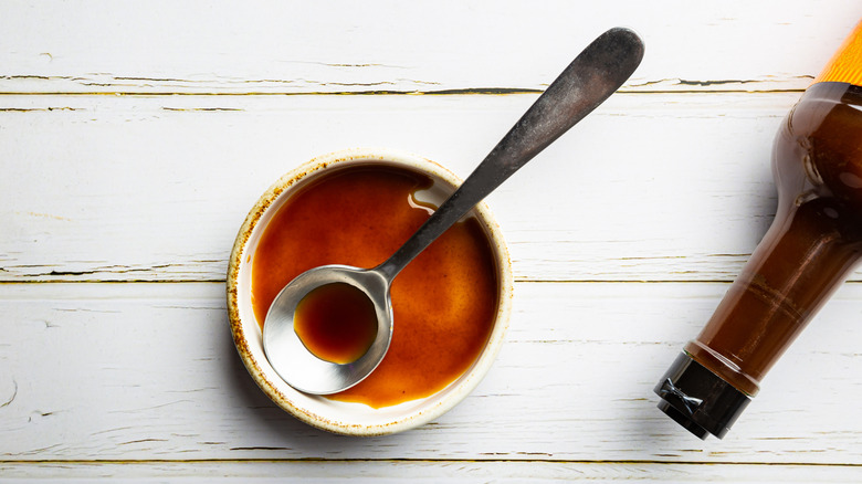 Bowl with spoon and Worcestershire sauce