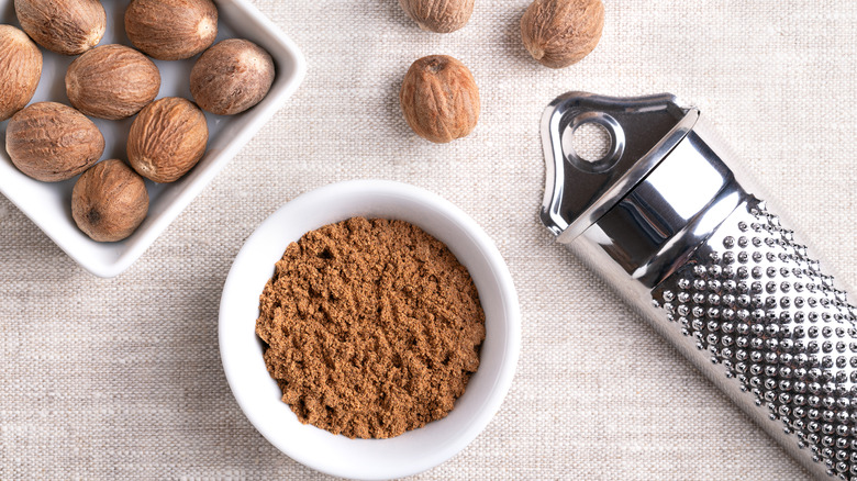 Whole nutmeg seeds and ground nutmeg with grater