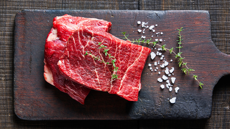 Raw flat iron steaks on a cutting board