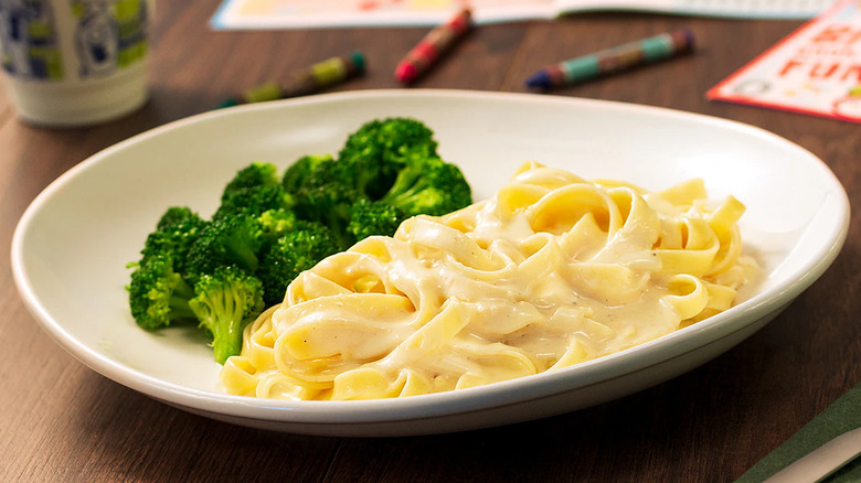 Pasta with Alfredo sauce and broccoli on white plate