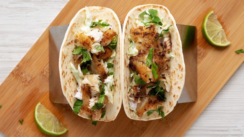 Overhead view of homemade tilapia tacos with cilantro and lime