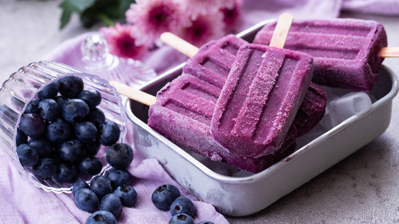 blueberry ice pops next to fresh blueberries