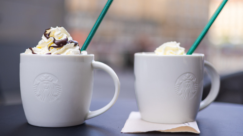 starbucks coffee mugs with whipped cream and green straws