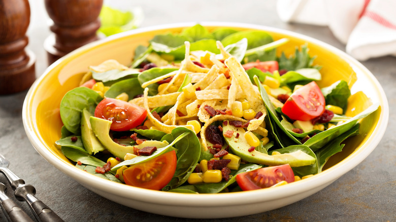 salad topped with tortilla strips in a yellow bowl