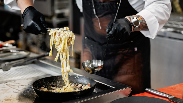 A chef preparing fettucine carbonara