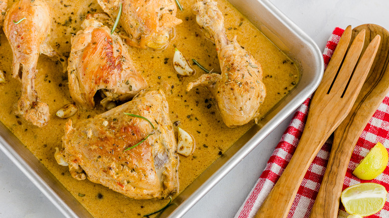 Chicken parts on a sheet pan full of golden brown sauce