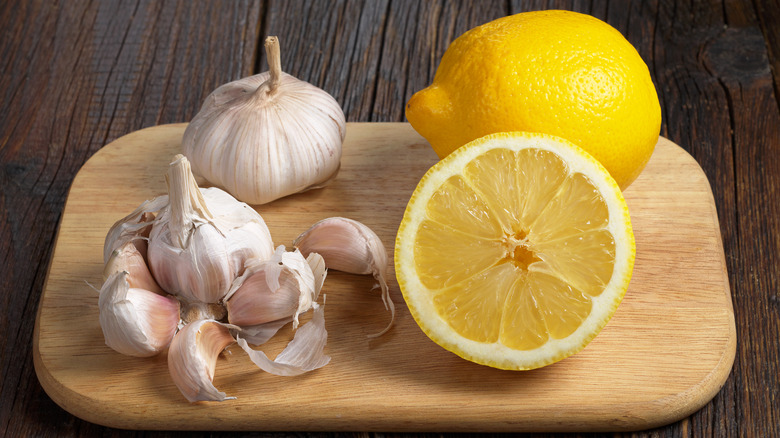 Lemon and garlic cloves on a wooden cutting board