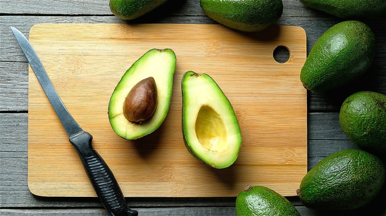 Halved avocado on cutting board