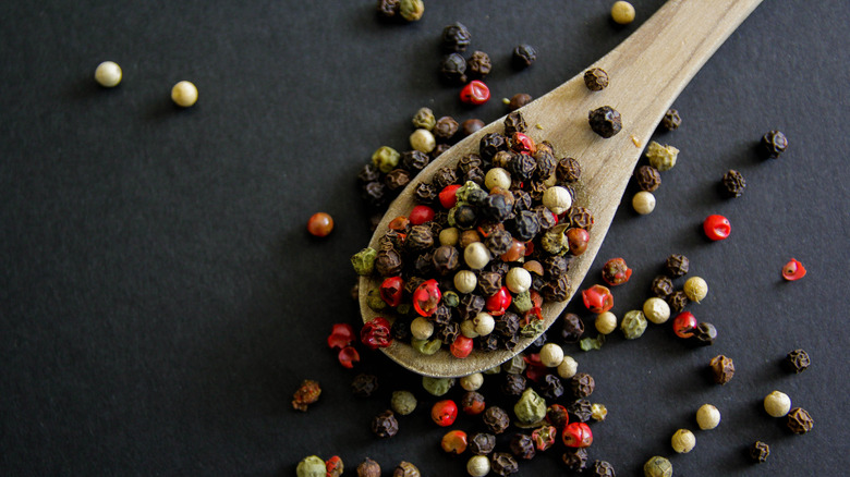 Wooden spoon with assorted peppercorns.