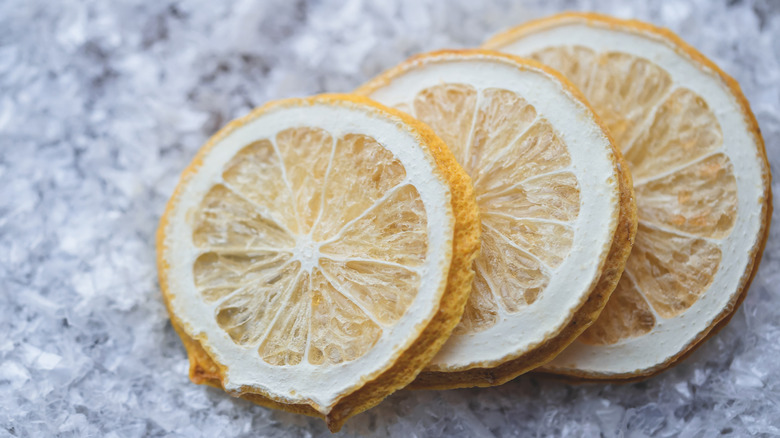 Slices of dried lemon rest on crushed ice