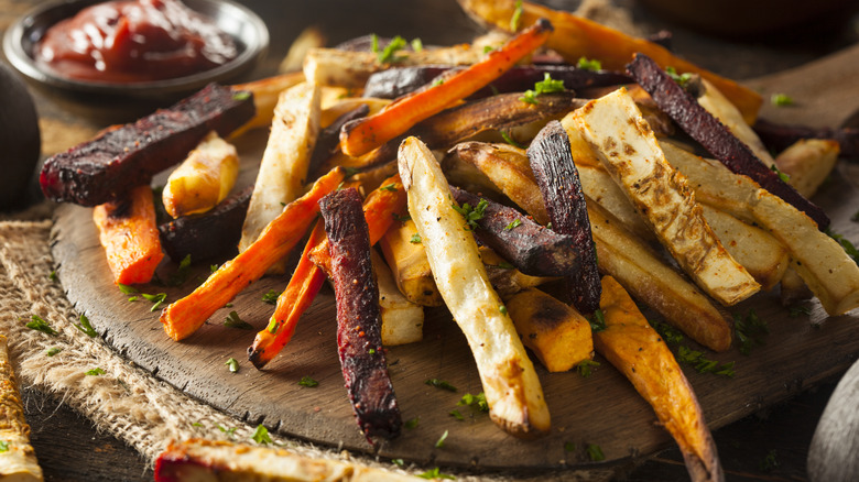 A variety of homemade vegetable fries on a wooden serving board