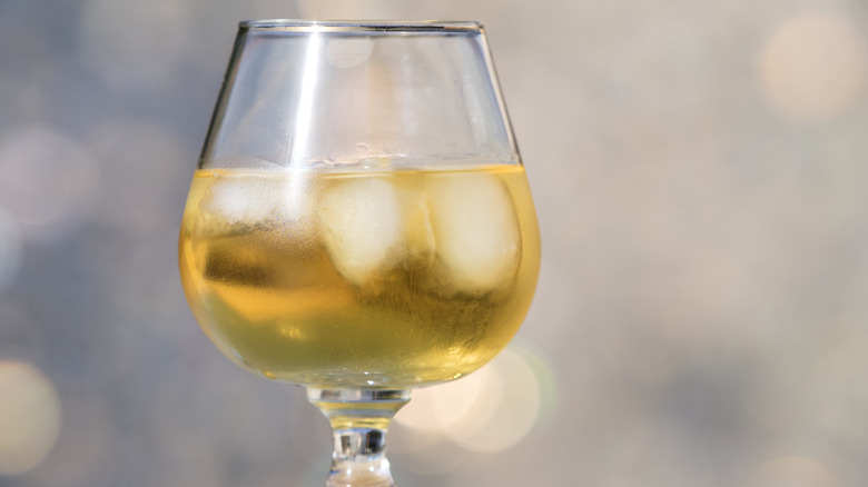 Glass of white wine with ice cubes