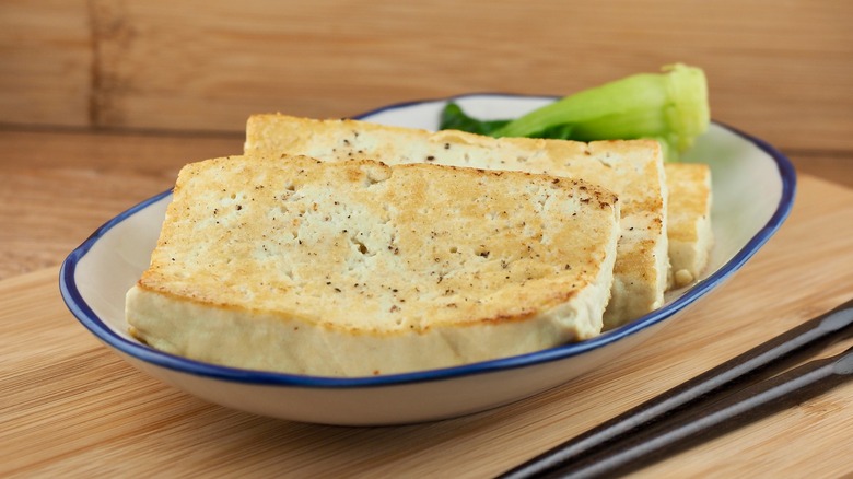 grilled tofu slices and greens on white and blue plate