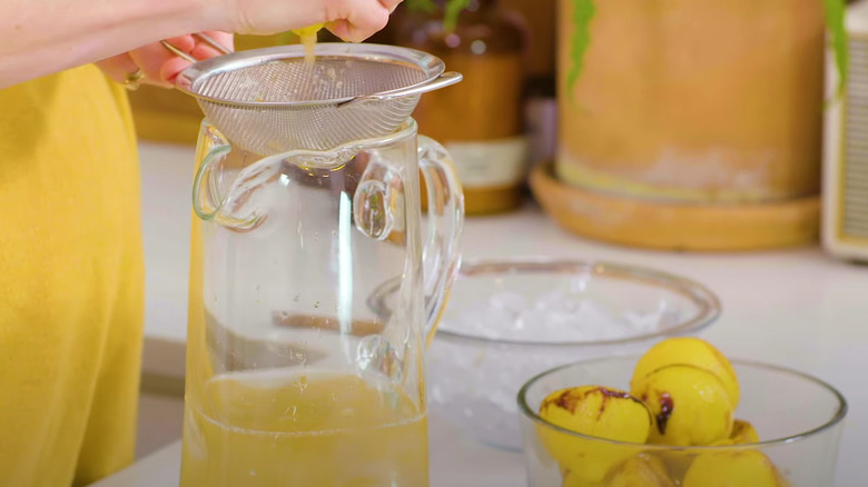 Squeezing roasted lemons into pitcher