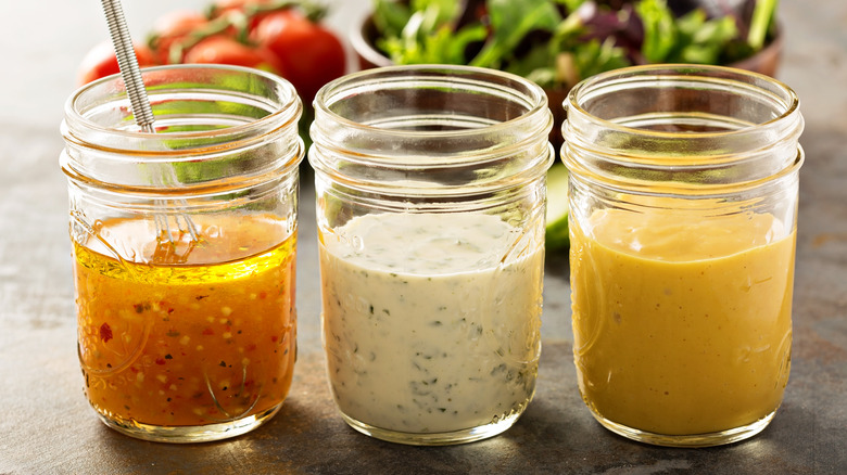 Three salad dressings in mason jars