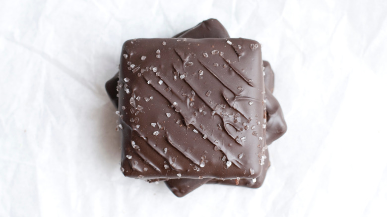 stack of graham crackers dipped in dark chocolate and covered in salt