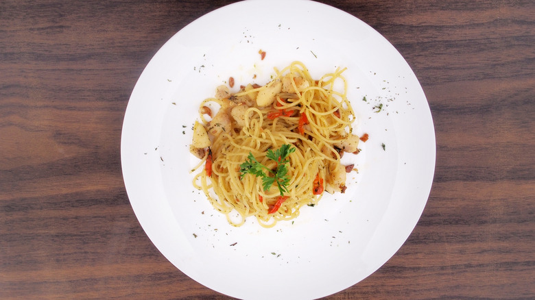 Spaghetti aglio e olio served on a white plate.