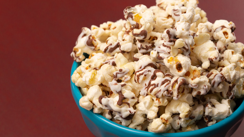 vanilla popcorn with chocolate drizzle in a blue bowl