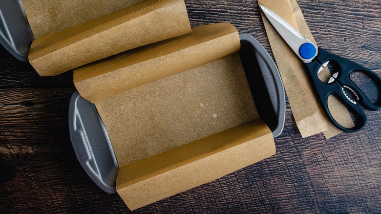 loaf pan with parchment paper next to scissors