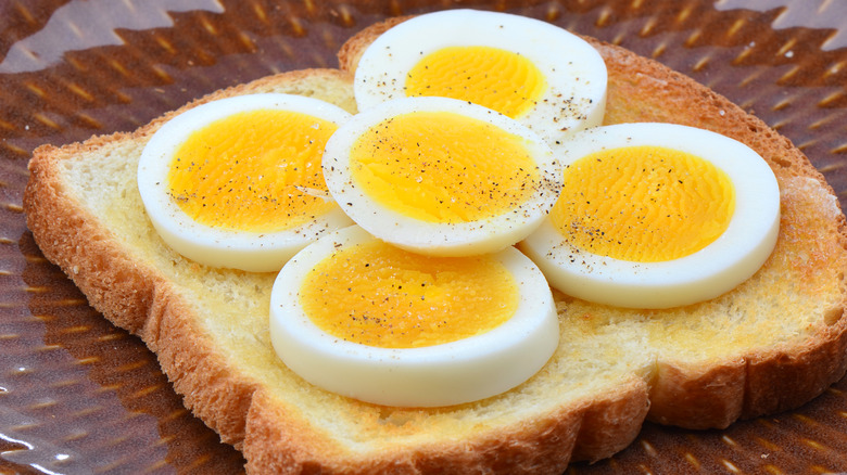 Sliced hard boiled eggs on buttered toast