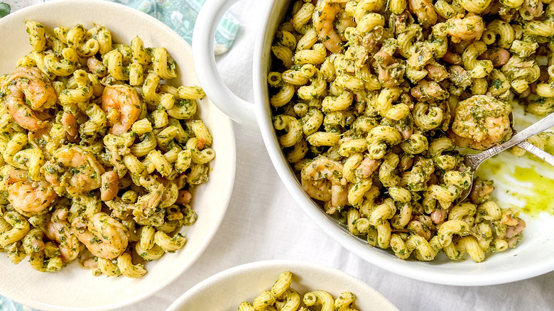 Closeup of walnut pesto pasta with shrimp in serving bowls