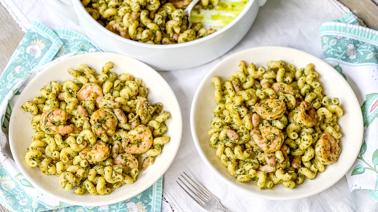 Walnut pesto pasta with shrimp in bowls on table