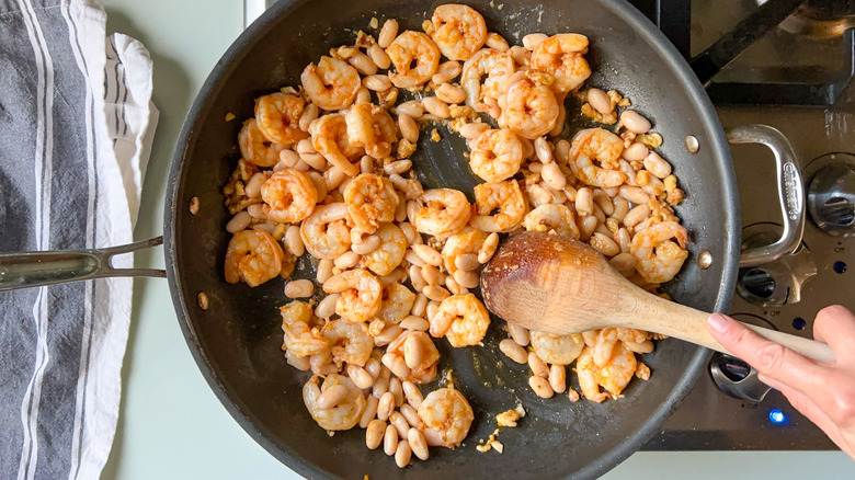 Shrimp and cannellini beans cooking in skillet