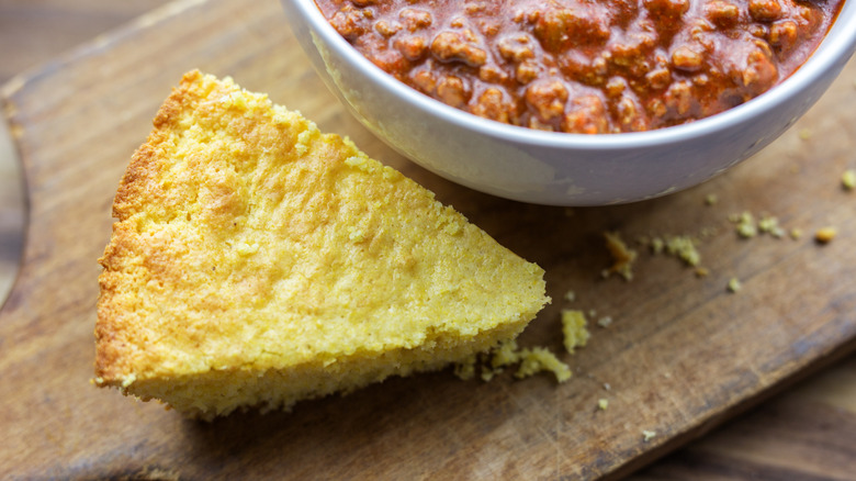 slice of cornbread next to bowl of chili