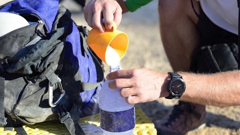 Pouring powder inside water bottle