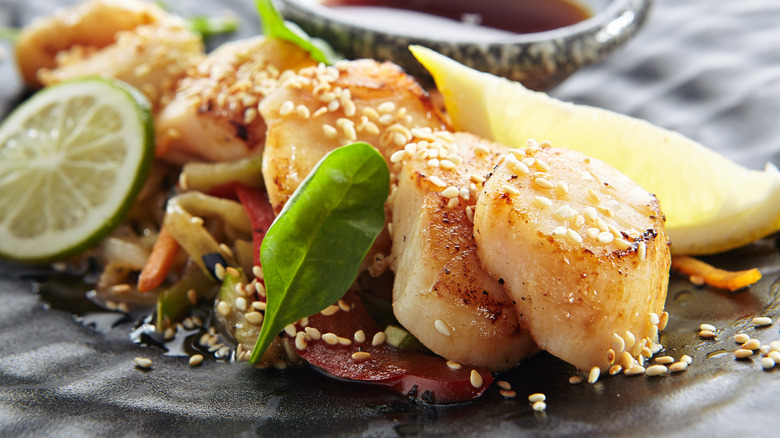 seared scallops with stir-fried vegetables and lemon
