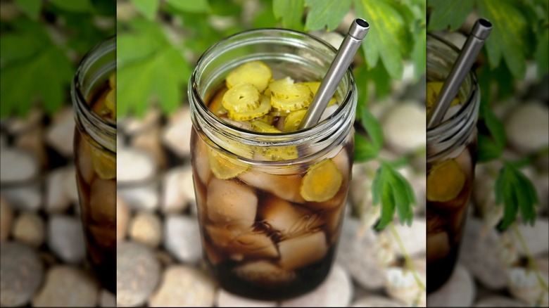 Mason jar with Dr Pepper and pickles, metal straw