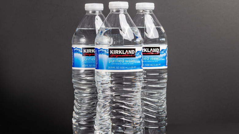 Three bottles of Kirkland Signature purified water.