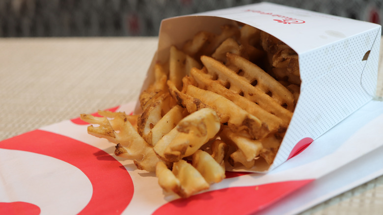 A container of Chick-fil-A Waffle Potato Fries is tipped on its side