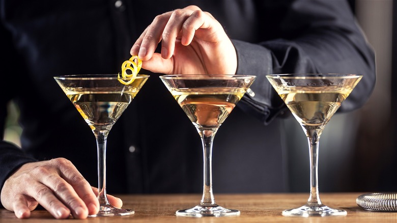 three martinis being garnished