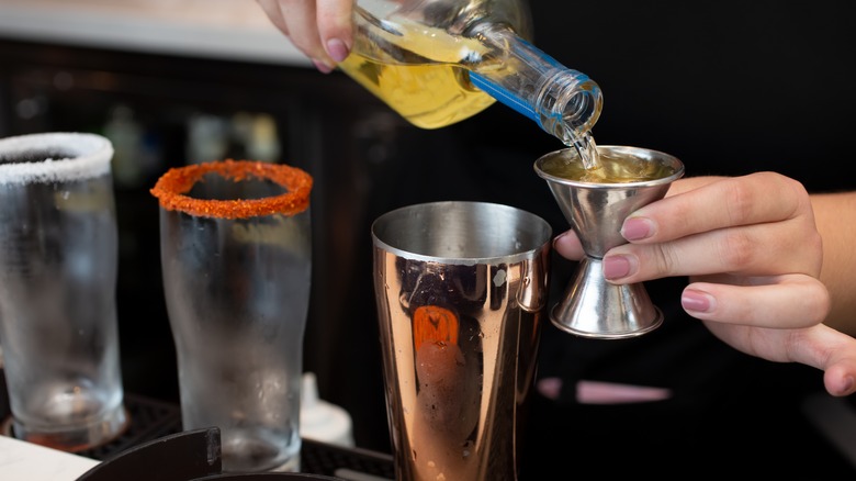 Bartender measuring drinks