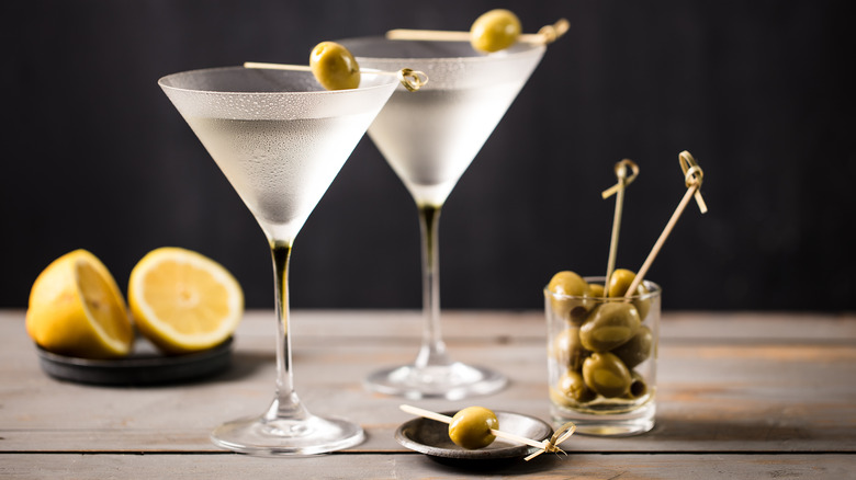 Two dry martini cocktails with olive garnish and lemon